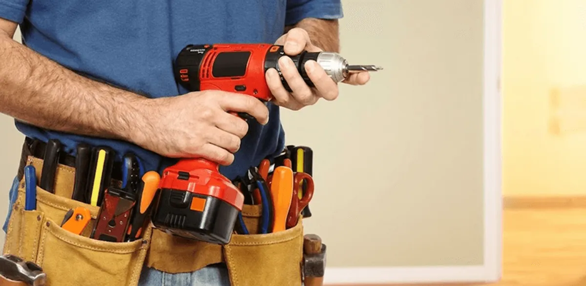 Handyman holding a power drill for home repairs and installations in Colorado Springs, CO